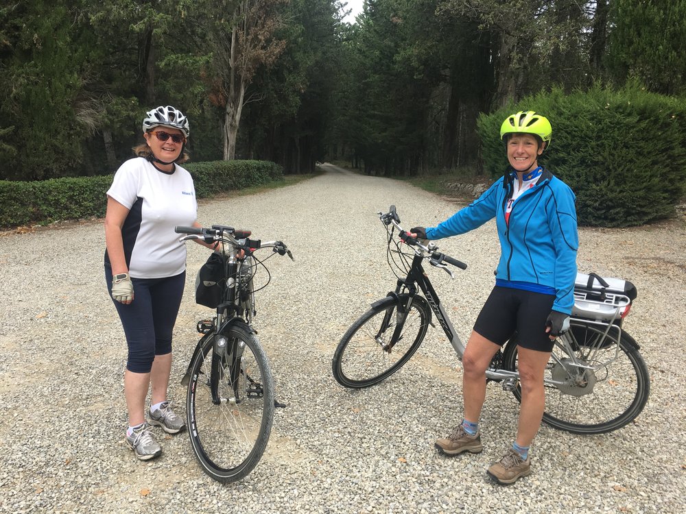 Karen and Becky on the ebikes reading to ride to Radda